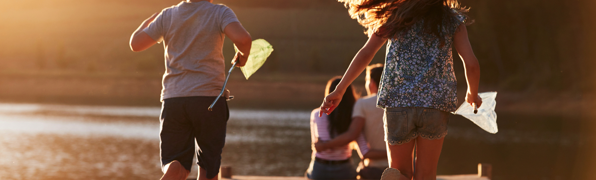 Kinder laufen auf hölzernen Steg am See auf Eltern zu - © Monkey Business - stock.adobe.com