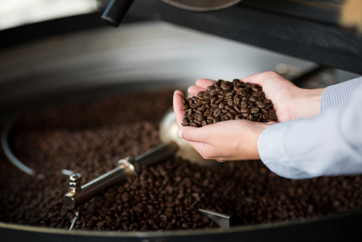 Frau in der Rösterei hält Kaffeebohnen in der Hand - © contrastwerkstatt - stock.adobe.com