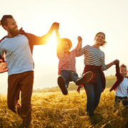 Glückliche Familie: Mutter, Vater, Kinder, Sohn und Tochter bei Sonnenuntergang
