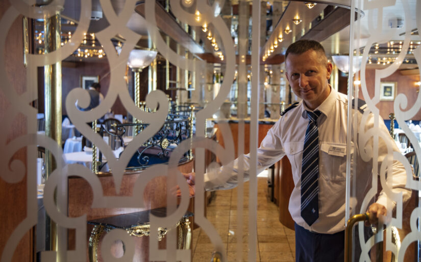 Maître d'hôtel Goran Kruscic welcomes guests at door of restaurant aboard boutique river cruise ship MS Thurgau Saxonia (Thurgau Travel), Wolgast, Mecklenburg-Western Pomerania, Germany
