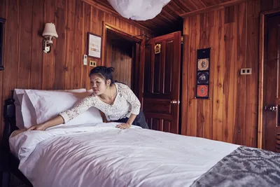 Mitglied des Housekeeping-Teams richtet das Bett in einer Kabine