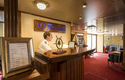 Hotelmanager an der Rezeption eines Flusskreuzfahrtschiffs