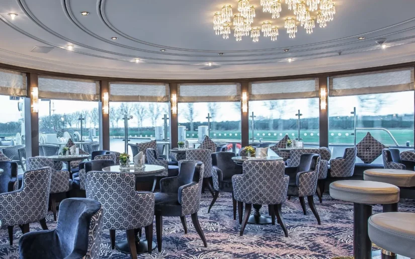 Panoramasalon der MS Moments mit Ausblick auf die Hafeneinfahrt.